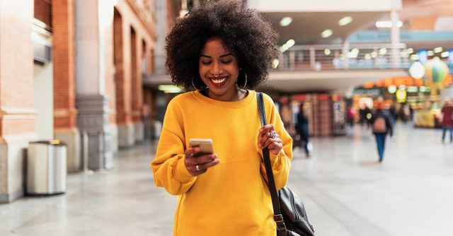 Beautiful woman using mobile in the train station. Communication concept